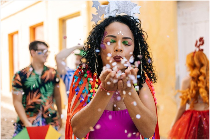 Imagem de mulher negra fantasiada e pintada em ritmo de carnaval